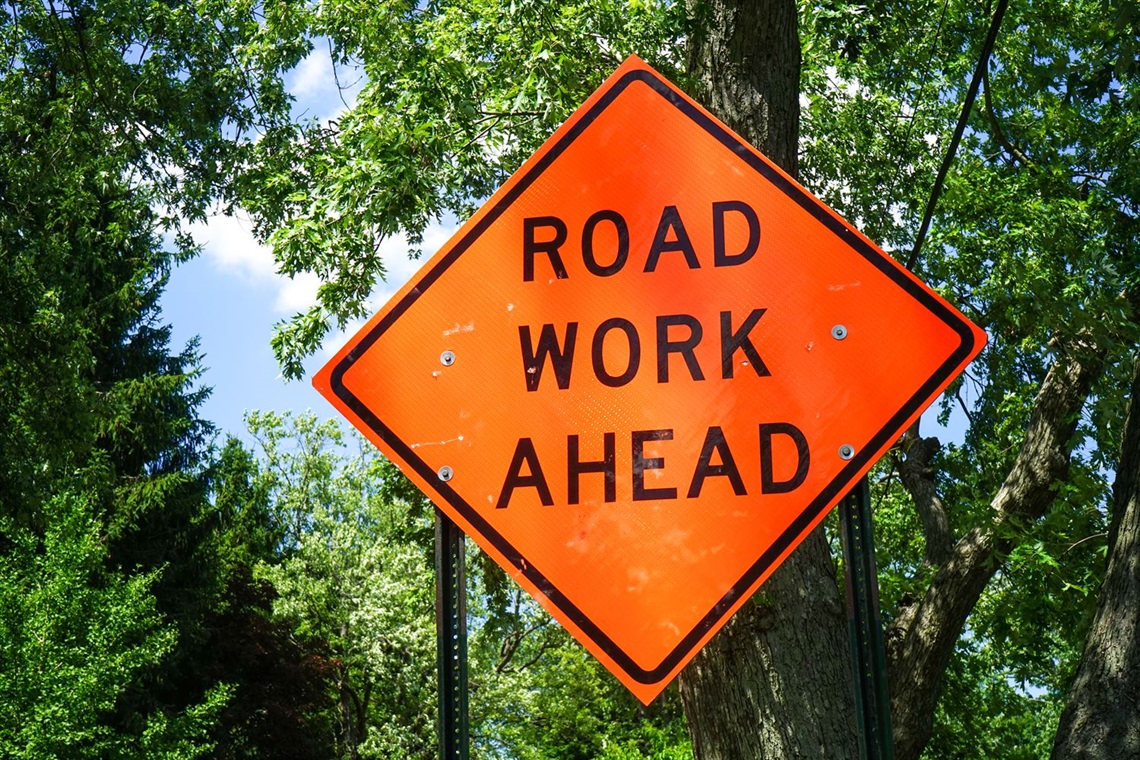Picture of road construction sign that says Road Work Ahead.
