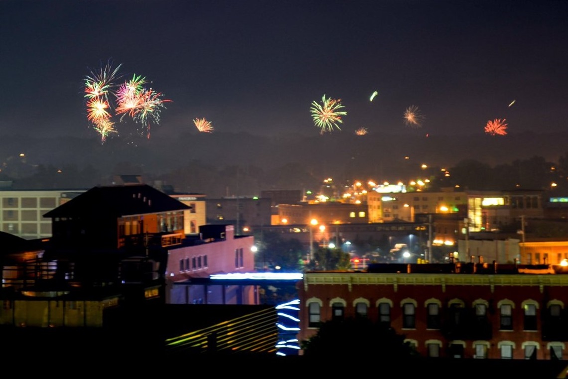 A photo of fireworks at night above buildings in downtown Kalamazoo. 